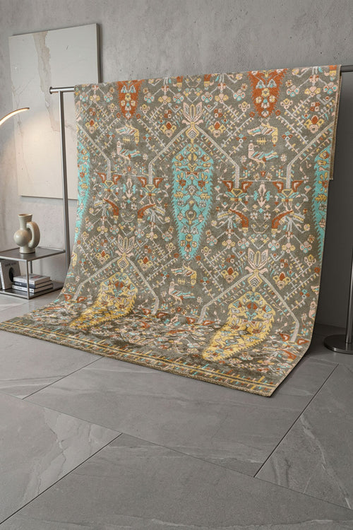 Load image 1 in gallery view. Olive green rug with a multi-colored traditional medallion pattern, draped on a display rack in a studio setting.