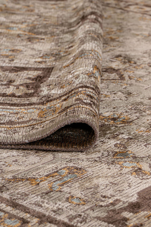 Load image 1 in gallery view. A close-up of the Ivory Medallion Area Rug APX1932 in neutral tones with blue and gold highlights, partially folded to reveal its thickness, medallion motif, and rich texture.