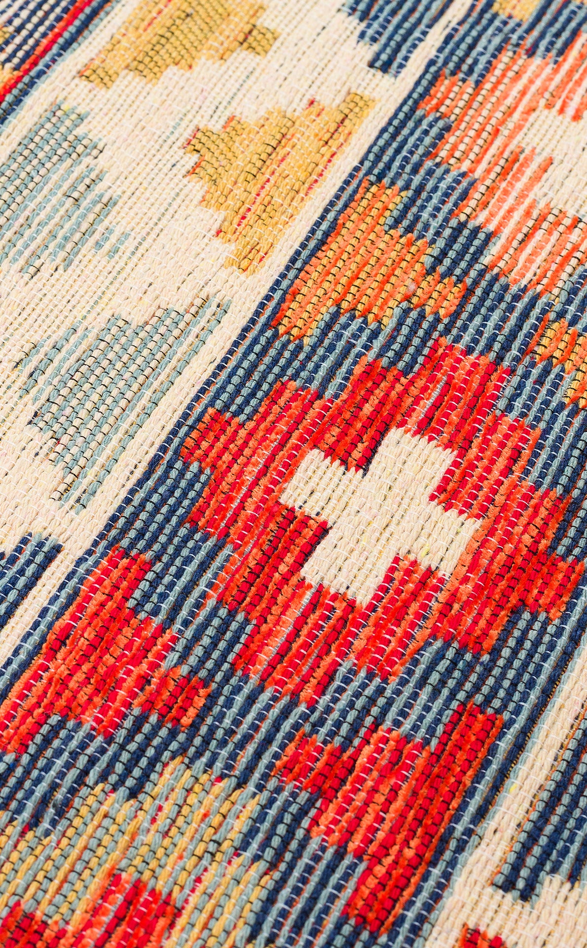 Close-up of the Aqua Flow - Washable Reversible Kilim (NMD02), featuring a vibrant folk-inspired Southwestern pattern with red, blue, yellow, and white geometric shapes and stripes.