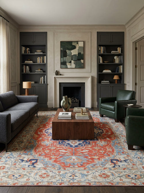 Load image 1 in gallery view. Traditional red, blue, and cream medallion rug in a formal living room with dark green leather chairs and a grey sofa.