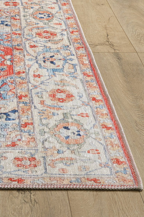 Load image 1 in gallery view. A close-up of the Ardentis Medallion Washable Rug - LCC3002 (Outlet) US, featuring intricate floral and geometric patterns in red, blue, and beige on a light wood floor.