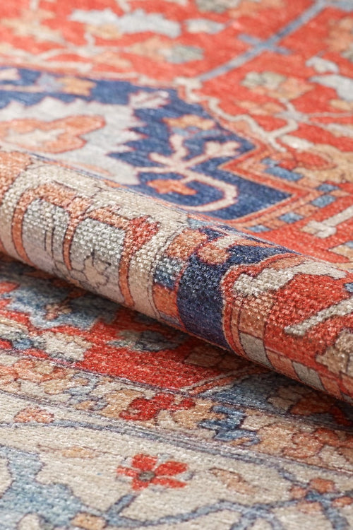 Load image 1 in gallery view. Close-up of a rolled corner of the Ardentis Medallion Washable Rug - LCC3002 (Custom Size), showing intricate red, blue, beige, and cream floral and geometric designs.