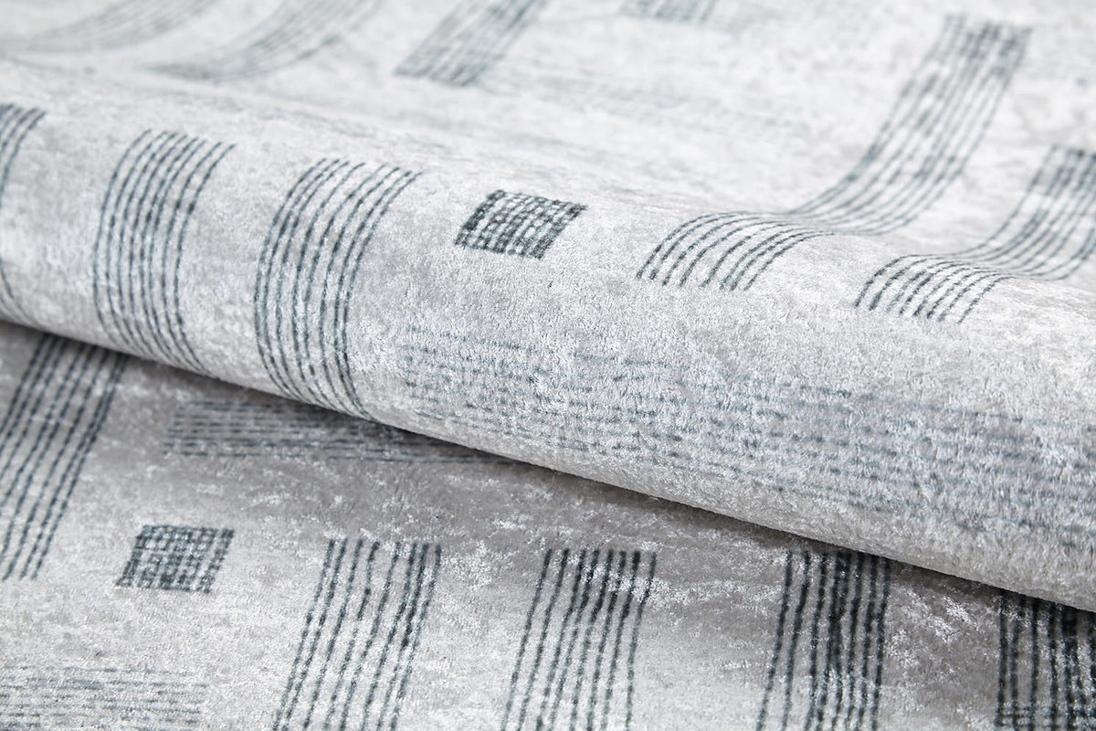 Close-up of the Art Deco Chic - Washable Rug - JR1832 (Custom Size) in light gray, featuring a modern design with dark gray lines and rectangles, highlighting its texture and sheen—perfect for high-traffic spaces.