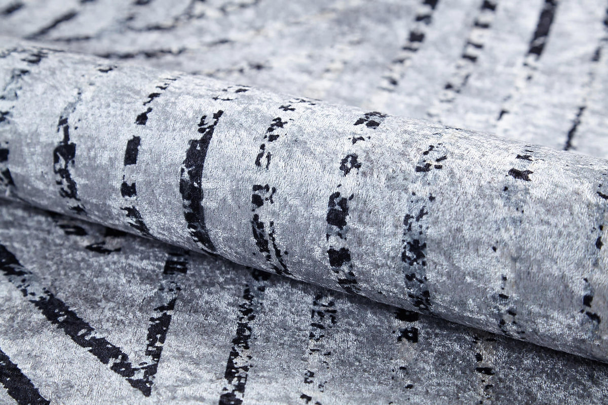 A close-up of the Art Deco Empress - Washable Rug - JR1867 (Custom Size) shows its gray-anthracite tones, irregular black lines, and abstract geometric patterns that create a modern, artistic look.