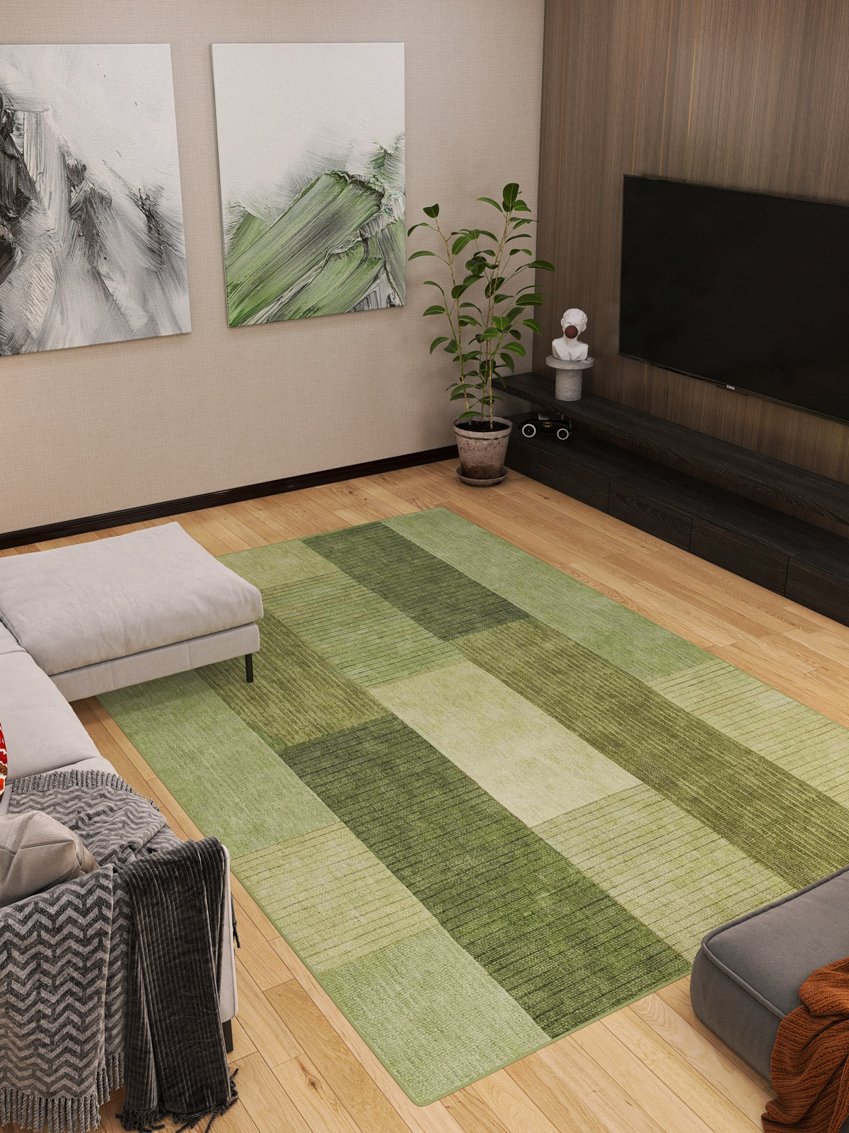 Modern living room featuring the Artisanal Essence - Washable Rug - JRN32 in green checkered design, ideal for high-traffic areas, gray sectional sofa, TV on dark wood stand, abstract green and white art, a corner plant, and light wood flooring.