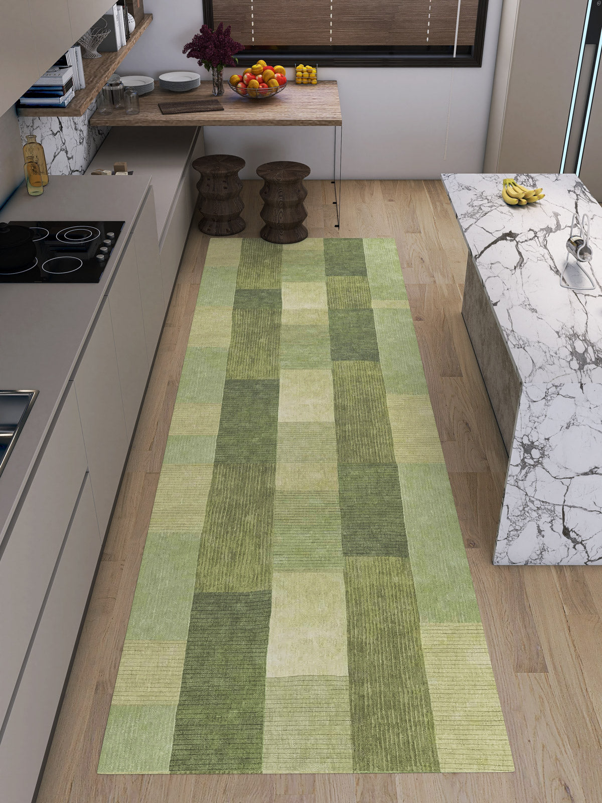 A modern kitchen with light wood floors, a marble island, two wooden stools, and Artisanal Essence - Washable Rug - JRN32 runner—ideal for high-traffic spots—plus fruit bowls, plants, and kitchenware on the countertop.