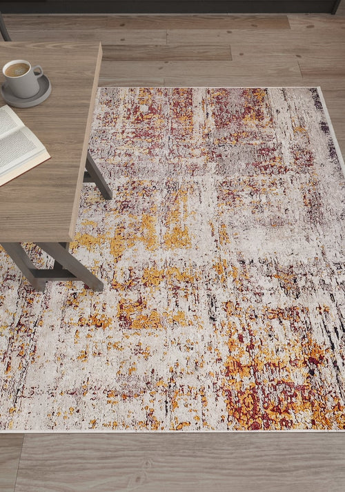 Load image 1 in gallery view. The Artistic Abstraction - Washable Rug - JR775 (Custom Size), featuring a modern abstract design in white, yellow, and burgundy, rests on a wood floor beside a light wood table with an open book and coffee cup.