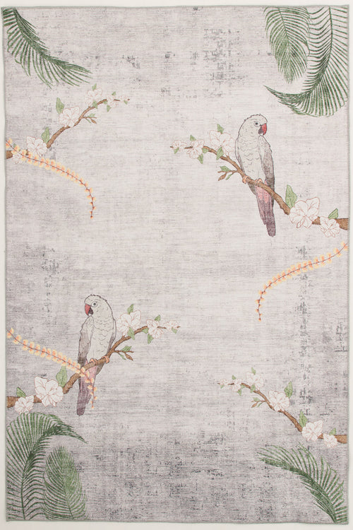 Load image 1 in gallery view. The Ashwing Silence - Washable Rug (JR0048) features two gray parrots with pink faces on flowering branches, green palm leaves, and orange floral vines in the corners. Its light-colored background has a subtle, textured look.