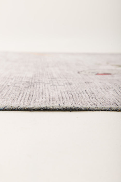 Load image 1 in gallery view. Close-up side view of the Ashwing Silence - Washable Rug - JR0048, featuring a thin, light-colored textured surface with subtle patterns on a neutral background. The edge is in focus, showcasing its low-profile design.