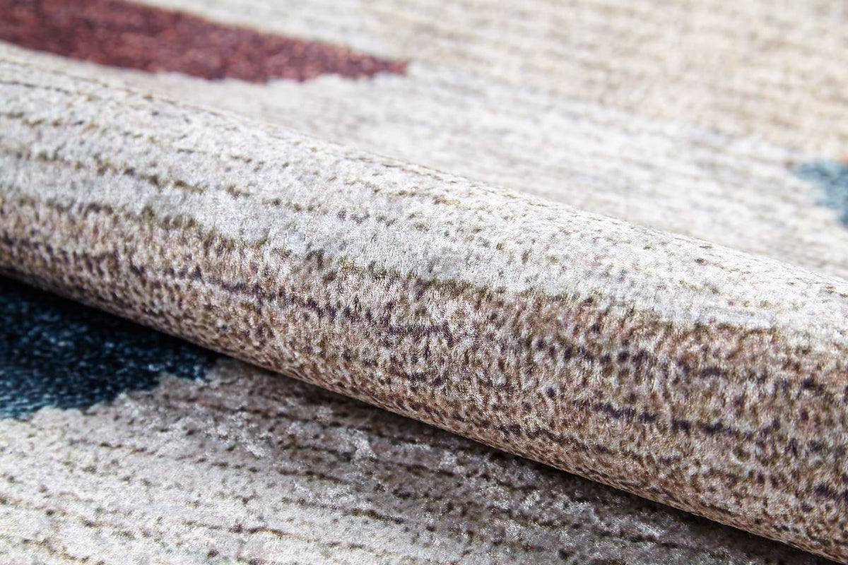 A close-up of the Asymmetrical Wonder - Washable Rug - JR1725 (Custom Size) shows its beige and brown textured surface with blue and red accents, soft fibers, and subtle patterns—perfect for high-traffic or allergy-sensitive spaces.