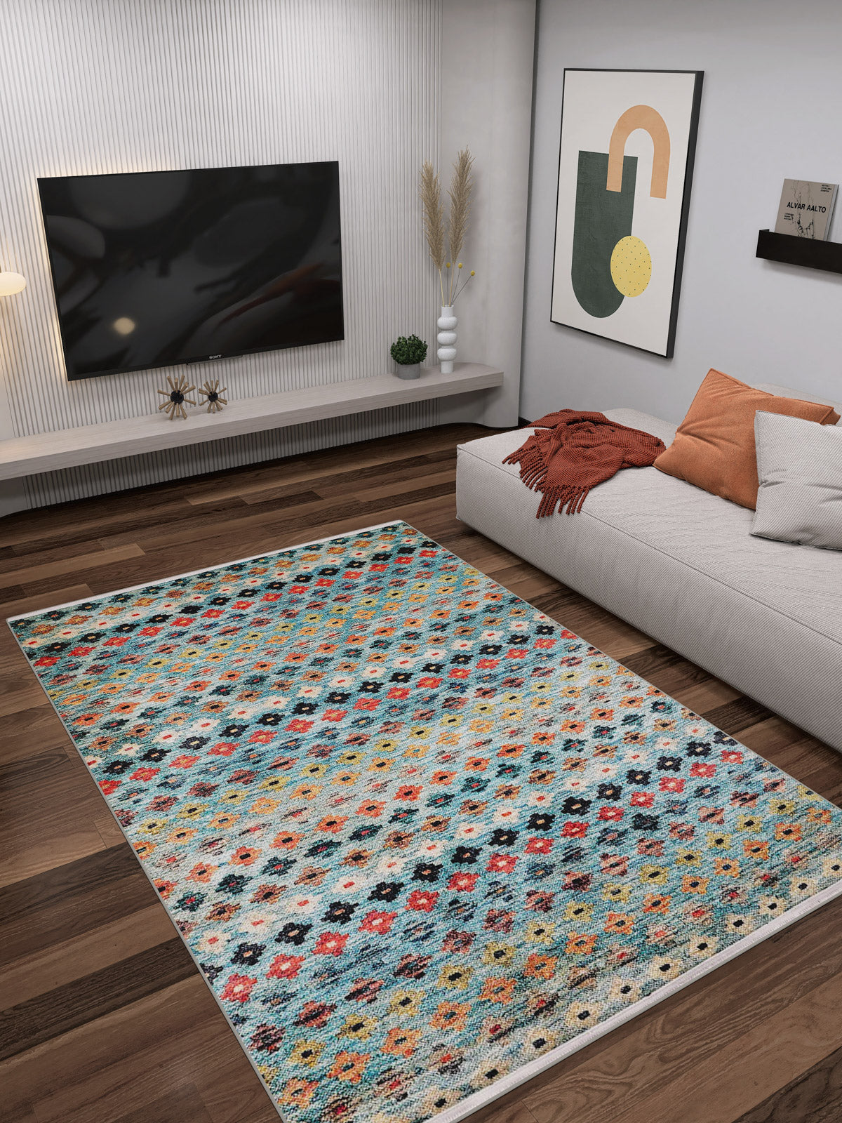 A modern living room with a wall-mounted TV, contemporary art, a beige sectional sofa with gray and rust pillows, and the Aztec Ambience - Washable Rug - JR1086 (Custom Size) for high-traffic areas on dark wood floors.