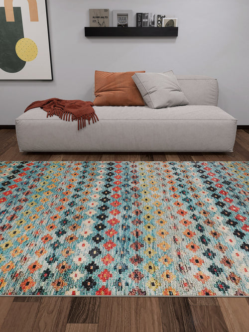 Load image 1 in gallery view. A modern living room with a light gray sofa, two pillows, a rust throw, the Aztec Ambience - Washable Rug - JR1086 (Custom Size) for high-traffic areas, wood floor, abstract wall art, and a black shelf with books and decor.