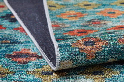 Load image 1 in gallery view. A close-up of the Aztec Ambience - Washable Rug - JR1086 (Custom Size) shows its multicolor design with a turquoise background and orange-yellow florals, plus a folded corner revealing the dark, textured underside—ideal for high-traffic areas.