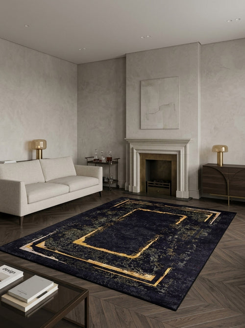 Load image 1 in gallery view. A modern living room features a light sofa, gold lamps, marble fireplace, minimal décor, and the Azure Glow - Washable Rug - JR1337 with gold geometric patterns—ideal for busy spaces—on brown herringbone wood and light gray walls.