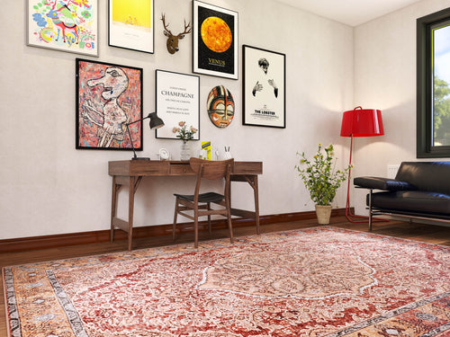 Load image 1 in gallery view. A home office features a wooden desk, chair, wall art above, and the Baroque Charm - Washable Rug - JRN1016 with a medallion design on the floor. A black sofa sits to the right and a red floor lamp stands near a sunlit window.