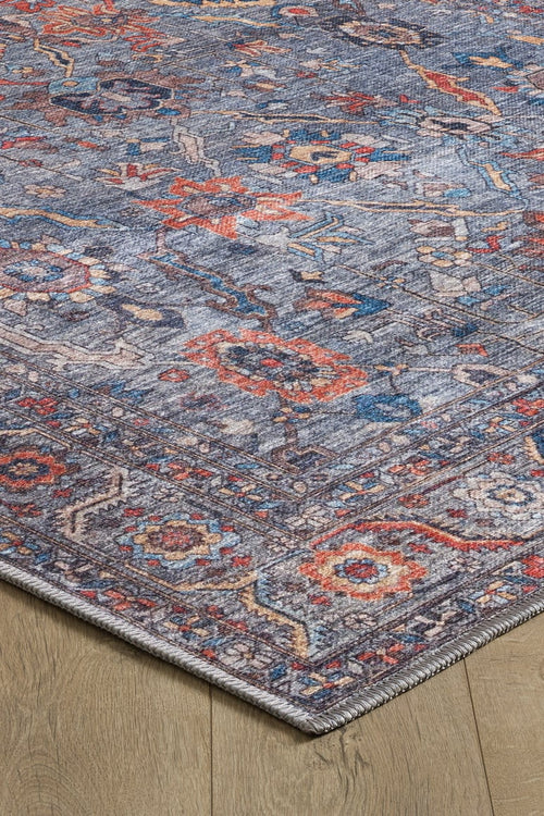 Load image 1 in gallery view. A close-up of the Bellaris Gray Washable Rug - LCC3003 (Outlet) US, featuring intricate red, blue, and orange floral patterns on a gray background, is shown placed on a light wooden floor.