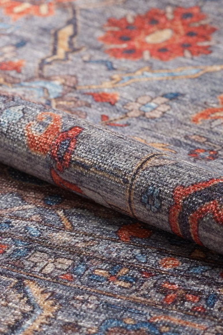 A close-up of the Bellaris Gray Washable Rug - LCC3003 (Custom Size) shows its allergy-friendly, flat weave surface with intricate floral and geometric patterns in gray, blue, red, orange, and cream for easy living.