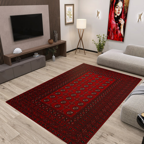 Load image 1 in gallery view. A modern living room showcases the Berry Pattern - Kilim - BHR04 rug, light wooden floors, a gray sofa, TV on a wood-paneled wall, floor lamp, potted plants, and a vibrant portrait of a woman