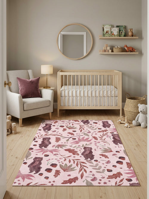 Load image 1 in gallery view. Pink rug with a woodland pattern of bears, leaves, and acorns, styled in a nursery.
