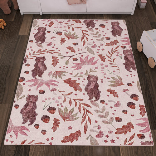 Load image 1 in gallery view. Pink rug with a pattern of brown bears, acorns, and leaves, styled in a nursery with dark wood flooring.