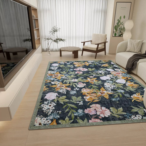 Load image 1 in gallery view. A modern living room with light wood floors, neutral furniture, and the Bloom Garden - Washable Rug - JRN1039 (Custom Size), featuring colorful florals and greenery. A big window with sheer curtains fills the space with natural light.