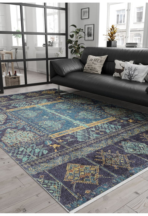 Load image 1 in gallery view. A modern living room with a black leather sofa, decorative pillows, the Blossoming Bazaar - Washable Rug - JR1862 in blue for high-traffic areas, potted plants, natural light from large windows, and black-framed glass partitions dividing the space.