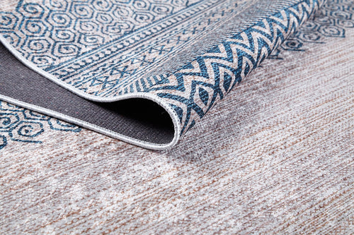 Load image 1 in gallery view. A close-up of the Bohemian Nights - Washable Rug - JR1585, folded to reveal its textured underside. Featuring blue geometric and zigzag designs on a light background, it's perfect for allergy-sensitive homes or high-traffic, neutral-toned floors.