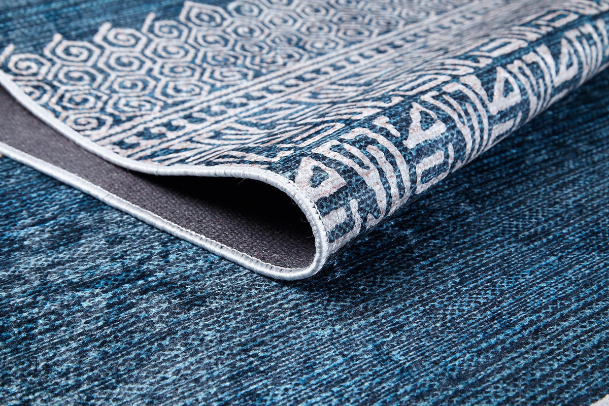 A close-up of the Bohemian Retreat - Washable Rug - JR1589 (Custom Size), showing its blue and white geometric patterns and textured underside. This washable rug is ideal for high-traffic areas with its intricate decorative designs.