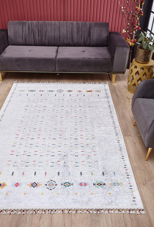 Load image 1 in gallery view. A modern living room with a gray velvet sofa, wood flooring, gold side table, and red vertical panels features the Boho Chic - Washable Rug - JR5103 (Custom Size), adding colorful geometric style and practicality to busy spaces.