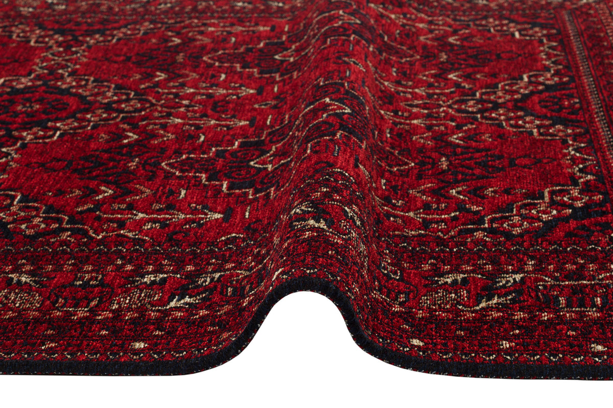 A close-up of the Bold Thread - Kilim - BHR05 rug, featuring an intricate red, black, and beige Turkish pattern with a visible ripple running through the center.