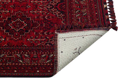 Load image 1 in gallery view. The Bold Thread - Kilim - BHR05 is a red, machine-made rug with intricate Turkish geometric and floral patterns, shown partly folded to display its light underside and fringed edge.
