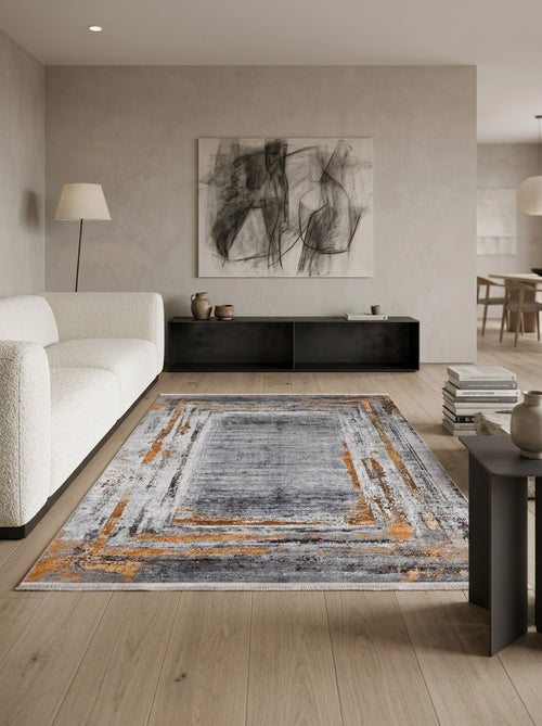 Load image 1 in gallery view. A modern living room features light wood flooring, a textured white sofa, abstract wall art, a black low console, floor lamp, and the Bold and Chic - Washable Rug - JR1198 in gray, orange, and cream—ideal for high-traffic spaces. Dining area in background.