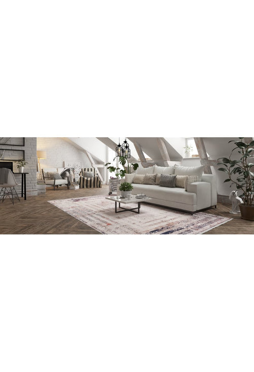 Load image 1 in gallery view. A cozy attic living room features a white sofa, neutral pillows, modern glass coffee table, potted plants, and the Bold and Geometric - Washable Rug - JR1410 on wood floors—ideal for high-traffic areas beneath slanted exposed-beam ceilings.