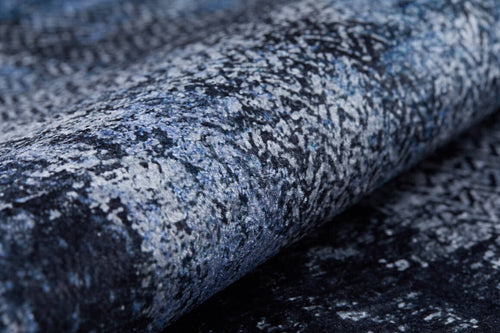 Load image 1 in gallery view. Close-up of the Bold and Minimalist - Washable Rug - JR1229 (Custom Size), featuring a textured, rolled-up surface with a mottled blue, grey, and black pattern—perfect for high-traffic areas and modern decor.