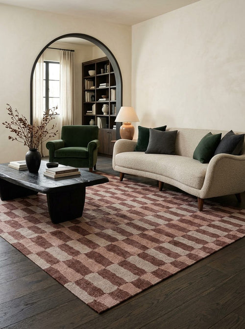 Load image 1 in gallery view. Rust and cream checkered rug in a living room with a curved sofa and dark wood floors.