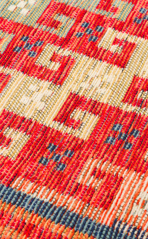 Load image 1 in gallery view. Close-up of the Canyon Shade - Washable Reversible Kilim - NMD11, featuring a vibrant red, yellow, white, and blue geometric tribal pattern. Its detailed texture is visible, making it a practical choice for high-traffic areas.