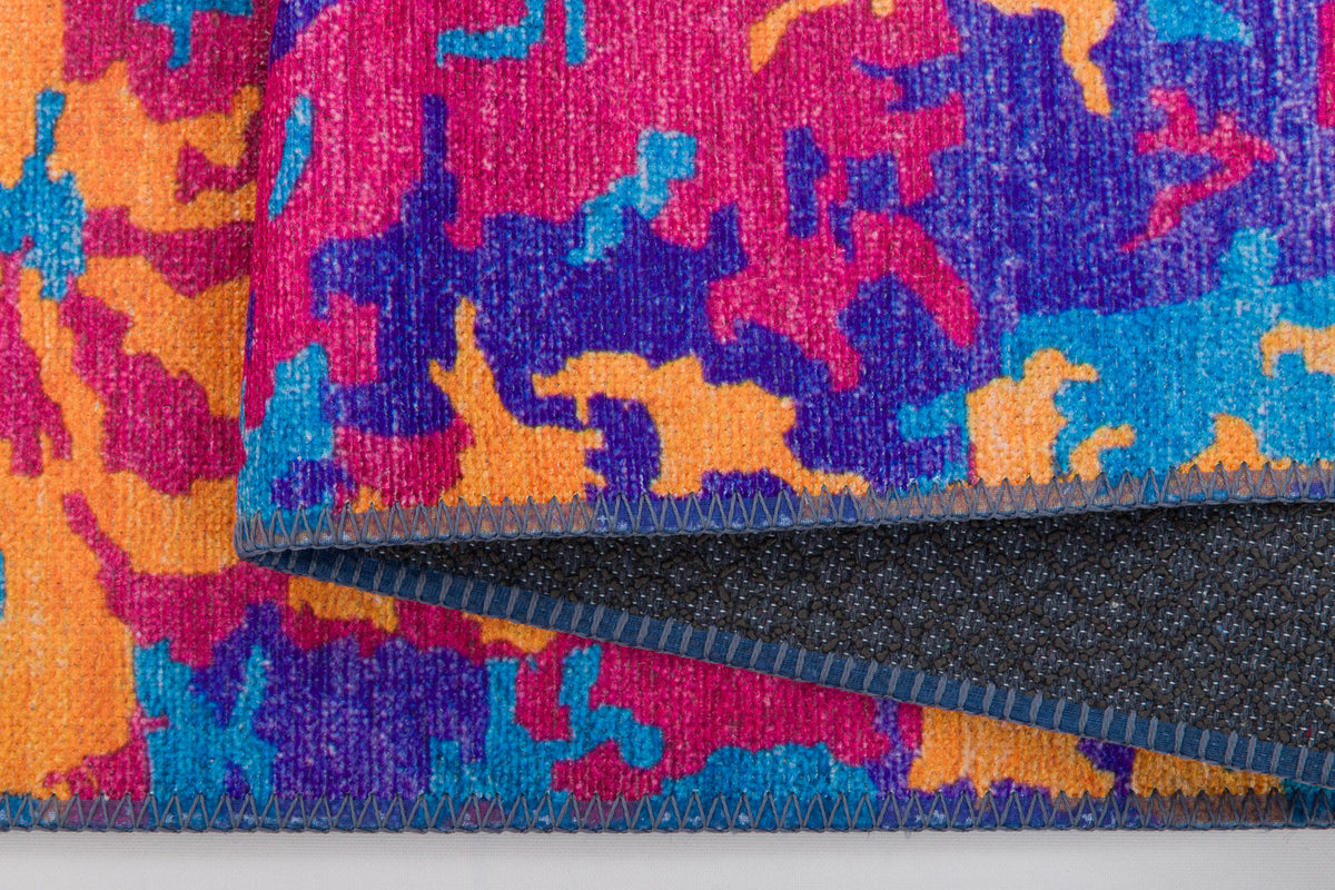 Close-up of the Celestial Tapestry Washable Rug (JRS004) in vibrant pink, orange, blue, and purple abstract patterns. Detailed stitching and dark backing are shown—perfect for high-traffic areas.