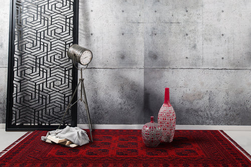 Load image 1 in gallery view. A modern interior featuring a gray concrete wall, a black geometric panel, a vintage floor lamp, two patterned vases with red accents, the Cherry Texture - Washable Kilim - BHR01 in red patterns, and a stack of books with gray cloth.