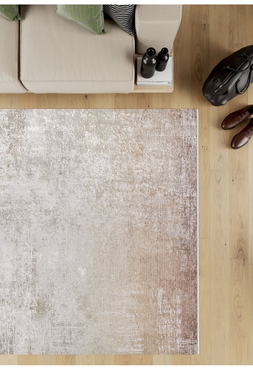Load image 1 in gallery view. A top-down view of a beige sofa with green pillows sits beside the Cinnamon Swirl - Washable Rug - JR425 (Custom Size) on a wooden floor, near a black bag, brown shoes, and two bottles atop a small stack of books.