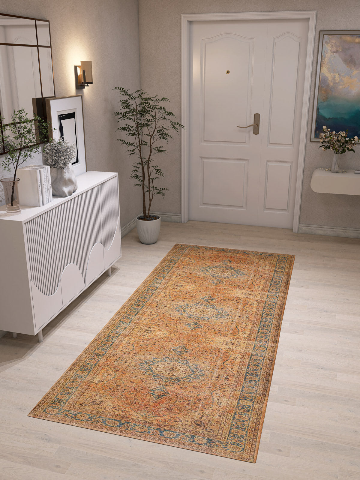 A hallway with light wood flooring features the Classic Laurel - Washable Rug - JRN1022 (Custom Size), a white sideboard with decor and art, a potted plant, a white door with gold handle, and a wall shelf displaying a floral vase.