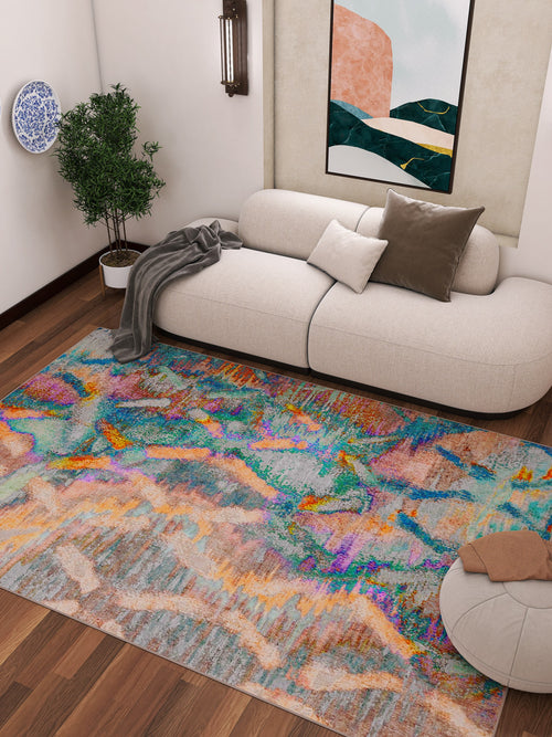 Bild 1 in Galerieansicht laden. A modern living room with a cream sofa, brown and white pillows, gray throw blanket, round ottoman, potted plant, wall art, and the Classic Motif - Washable Rug - JRN29 with geometric patterns—ideal for high-traffic wooden floors.