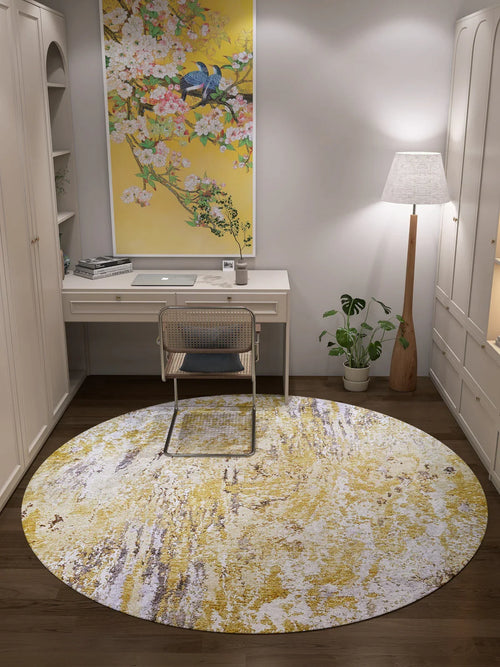 Bild 1 in Galerieansicht laden. A tidy home office with a white desk, chair, lamp, tall plant, and floral bird artwork above the desk. The floor features the Color Splash - Washable Rug - JR146 in yellow-gold with white patterns—ideal for high-traffic areas.