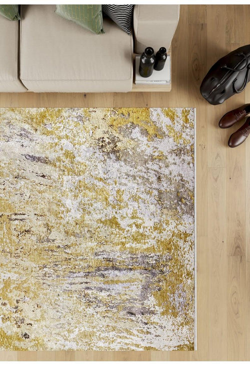 Bild 1 in Galerieansicht laden. Overhead view of a beige sofa with green cushions, coffee table, brown shoes, and a black bag on light wood floors with the Color Splash - Washable Rug - JR146 in yellow-gold—ideal for high-traffic areas.