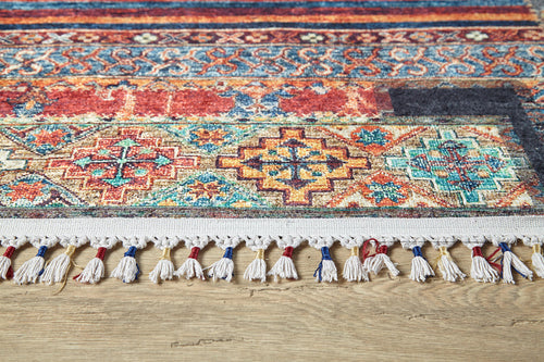Load image 1 in gallery view. A close-up of the Colorful Composition - Washable Rug - JR5107 (Custom Size), showcasing its intricate multicolor geometric patterns and white fringe with blue and red threads, placed on a light wooden floor—perfect for high-traffic areas.