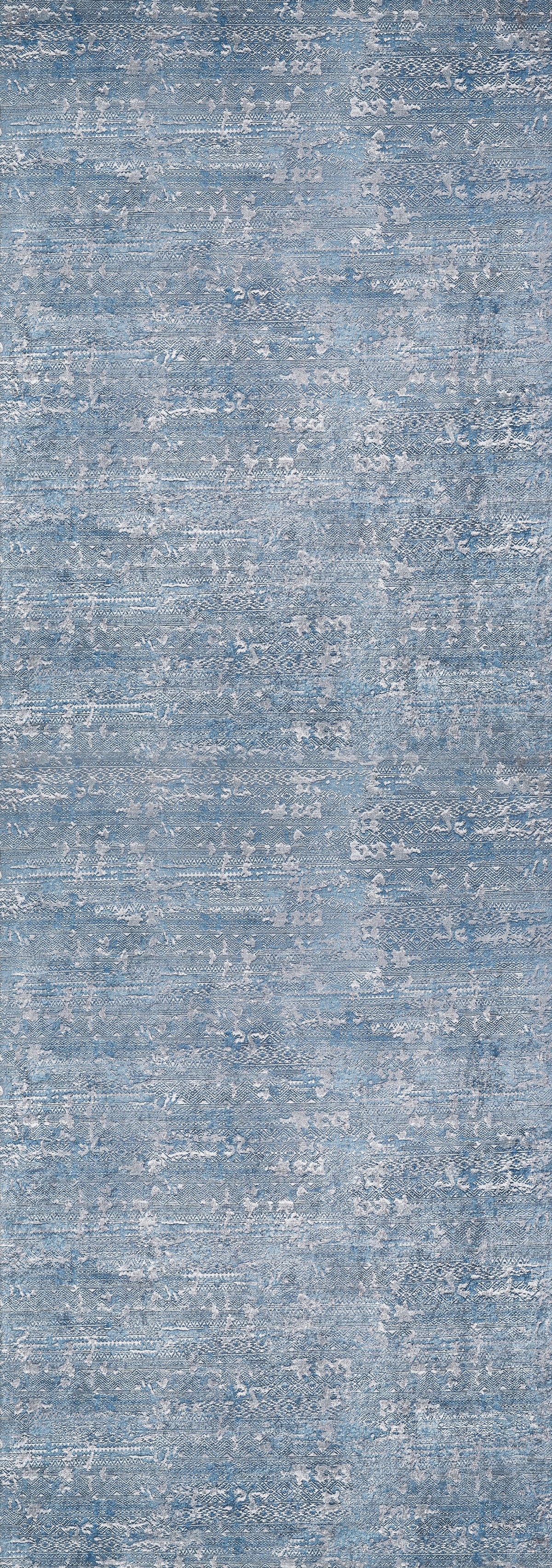 The Contemporary Serenity - Machine-Washable Rug JR1884 features a blue and gray mottled design with a textured, fabric-like look. Its soft surface and washable material make it ideal for high-traffic spaces, blending style with practical durability.