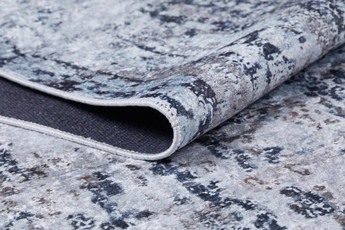 Load image 1 in gallery view. A close-up of the Creative Currents - Washable Rug - JR835 (Custom Size) shows its folded corner and textured pattern in blue, gray, and white—this modern, soft rug offers stylish design perfect for any space.