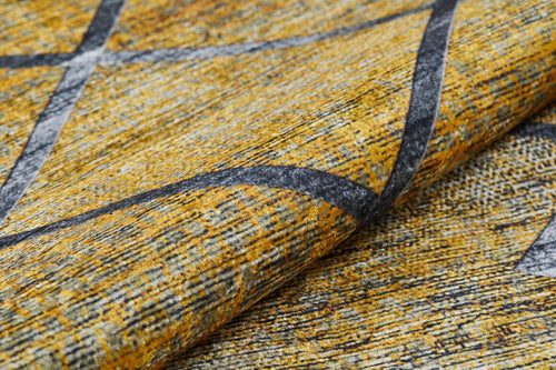 Load image 1 in gallery view. Close-up of the Crossed Connections - Washable Rug - JR1181 (Custom Size), featuring a textured yellow and gray surface with mottled patterns and intersecting dark lines—washable, durable, and ideal for high-traffic areas; fabric shown slightly folded in front.