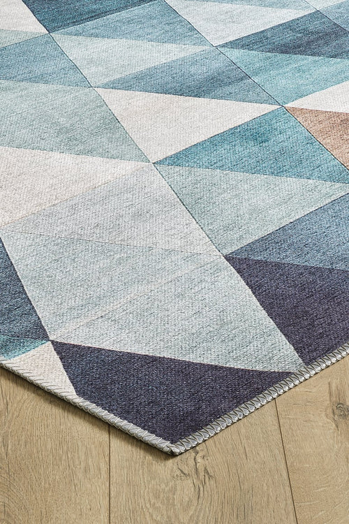 Load image 1 in gallery view. A close-up of the Cubism Collage Blue Washable Rug - MDJ008 (Custom Size), featuring blue, teal, gray, and beige geometric triangles—ideal for high-traffic areas and shown on a light wood floor.