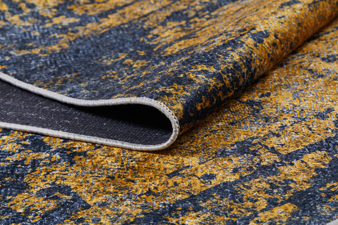 A close-up of the Diagonal Dash - Washable Rug - JR1310 (Custom Size) shows its yellow and black textured pattern, folded corner, and stitched beige edge—ideal as a washable rug for high-traffic areas.