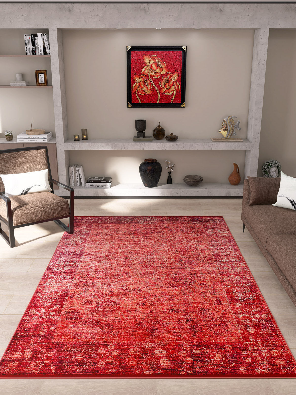 A modern living room with beige walls features the Dynasty Dream - Washable Rug - JR160 in a red oriental pattern, a brown armchair and sofa, shelves with decor items, and a framed red abstract artwork above the shelves.